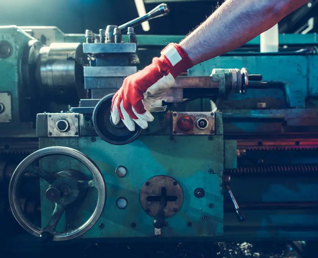 a person wearing gloves and working on a machine